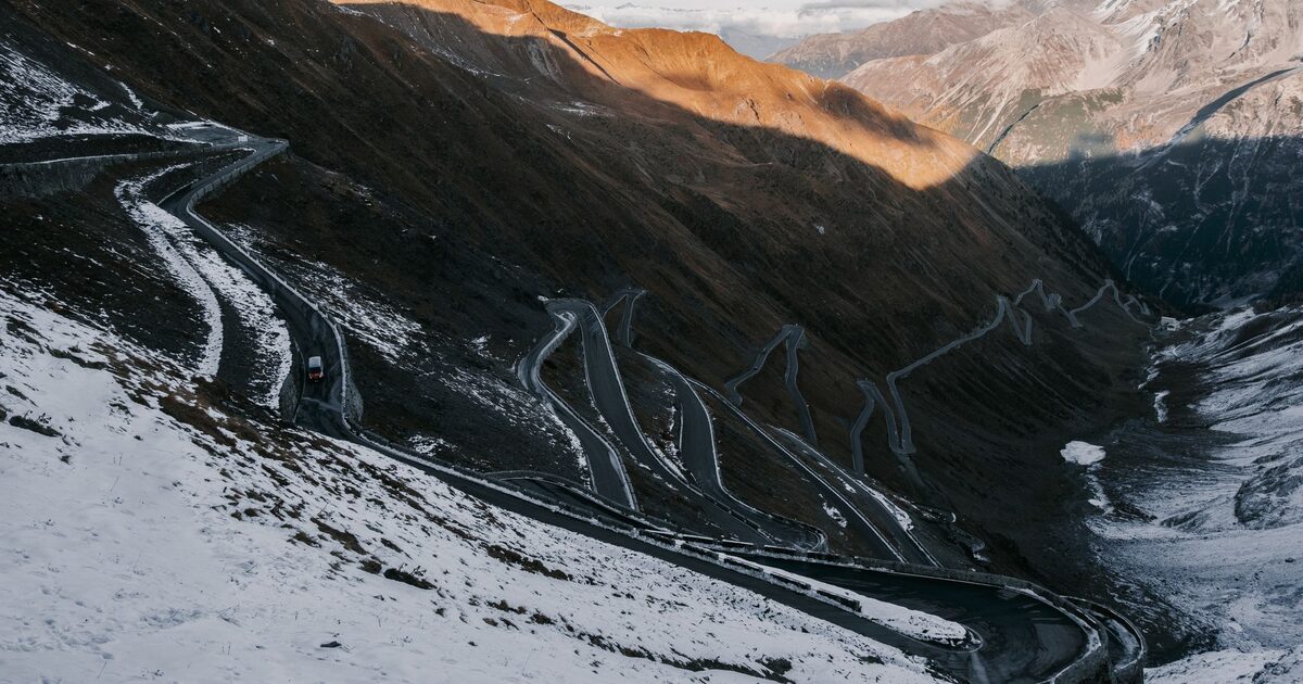 A snow-covered mountain pass with dozens of hairpin switchbacks, the Stelvio Pass in the Italian Alps